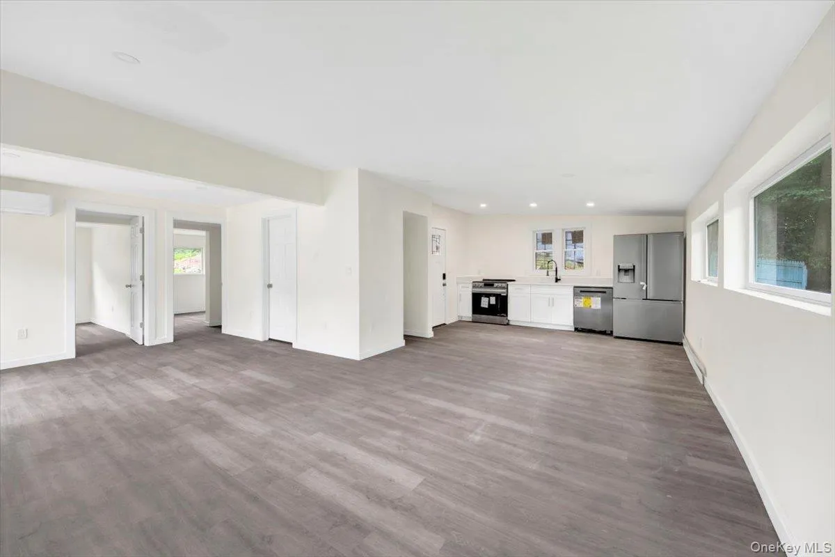 Unfurnished living room featuring wood finished floors, recessed lighting, and a wall unit AC Unfurnished living room featuring wood finished floors, recessed lighting, and a wall unit AC