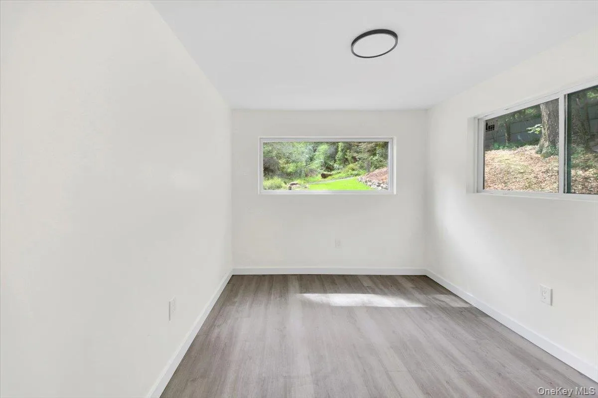 Spare room with wood finished floors and baseboards Spare room with wood finished floors and baseboards