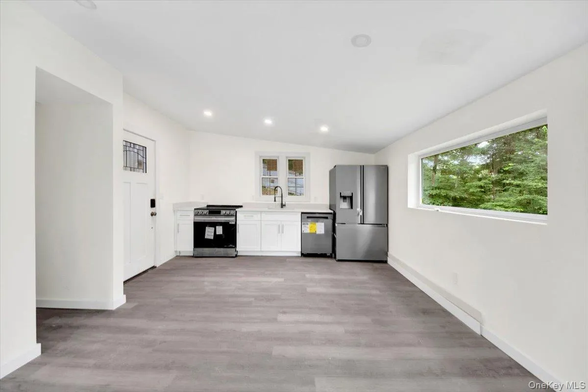 Kitchen featuring stainless steel appliances, light countertops, white cabinetry, light wood-style flooring, and recessed lighting Kitchen featuring stainless steel appliances, light countertops, white cabinetry, light wood-style flooring, and recessed lighting