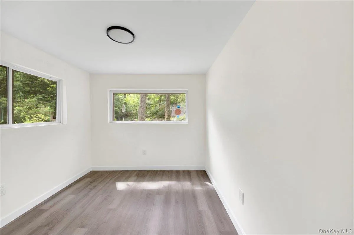 Spare room featuring wood finished floors and baseboards Spare room featuring wood finished floors and baseboards
