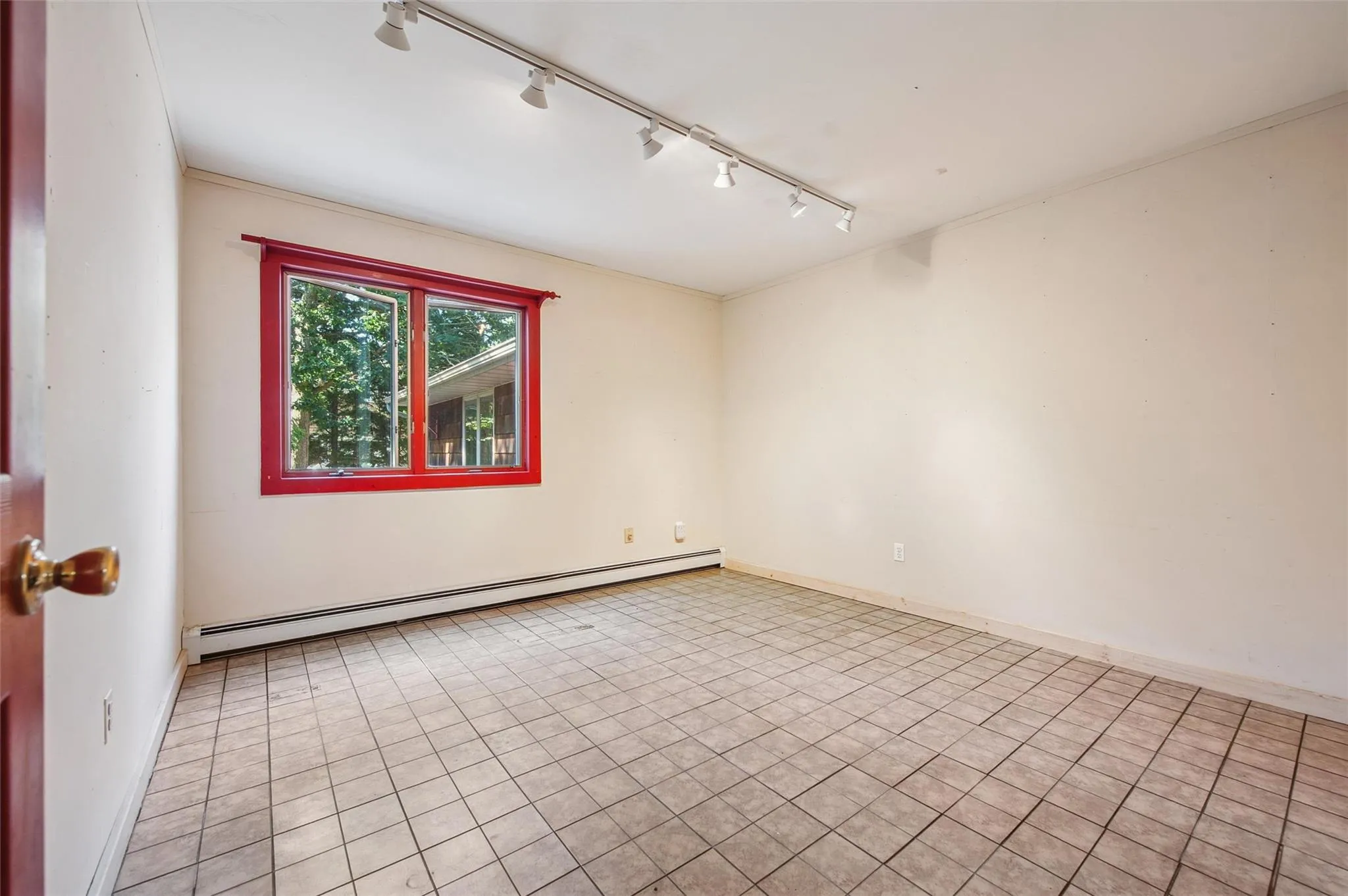 Unfurnished room featuring baseboard heating, track lighting, and light tile patterned floors Unfurnished room featuring baseboard heating, track lighting, and light tile patterned floors