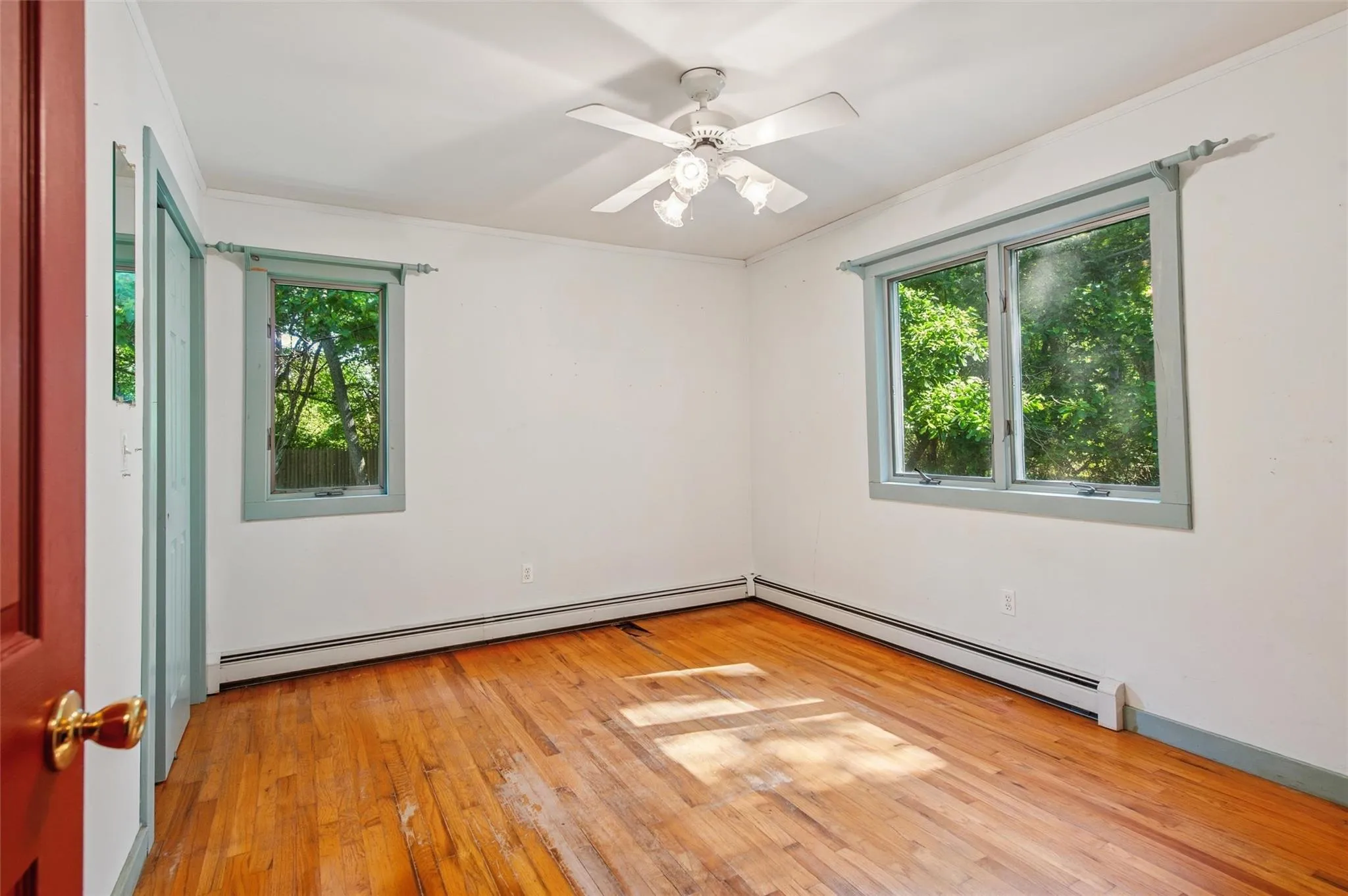 Unfurnished room with a baseboard heating unit, light wood-style floors, and ceiling fan Unfurnished room with a baseboard heating unit, light wood-style floors, and ceiling fan