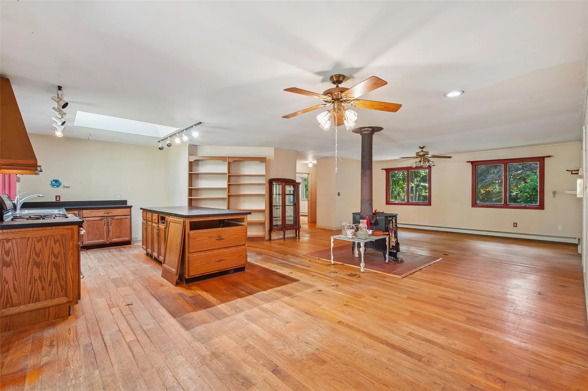 Kitchen with dark countertops, brown cabinets, baseboard heating, and a skylight Kitchen with dark countertops, brown cabinets, baseboard heating, and a skylight