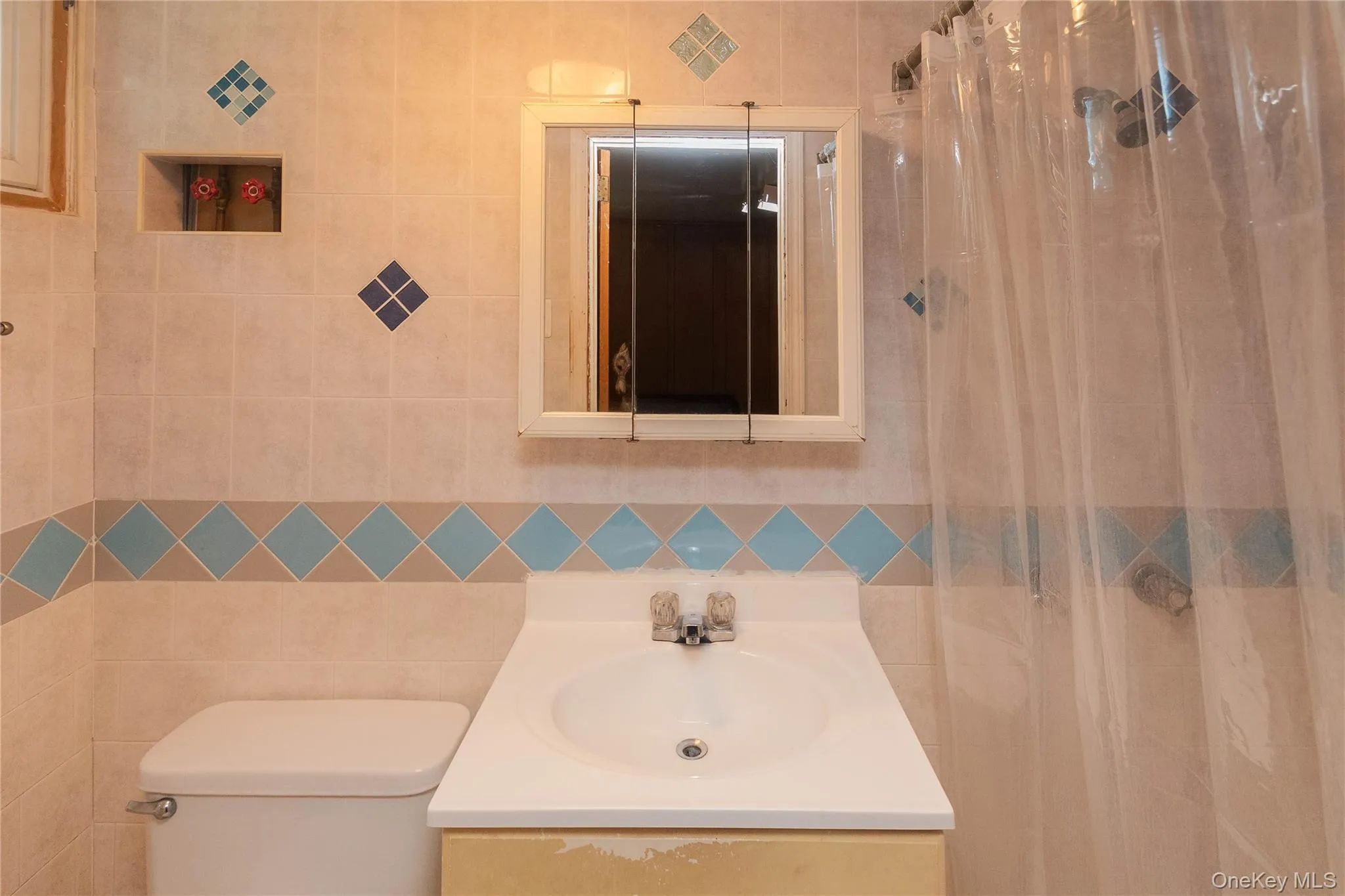 Bathroom with vanity, tile walls, and a shower with curtain Bathroom with vanity, tile walls, and a shower with curtain