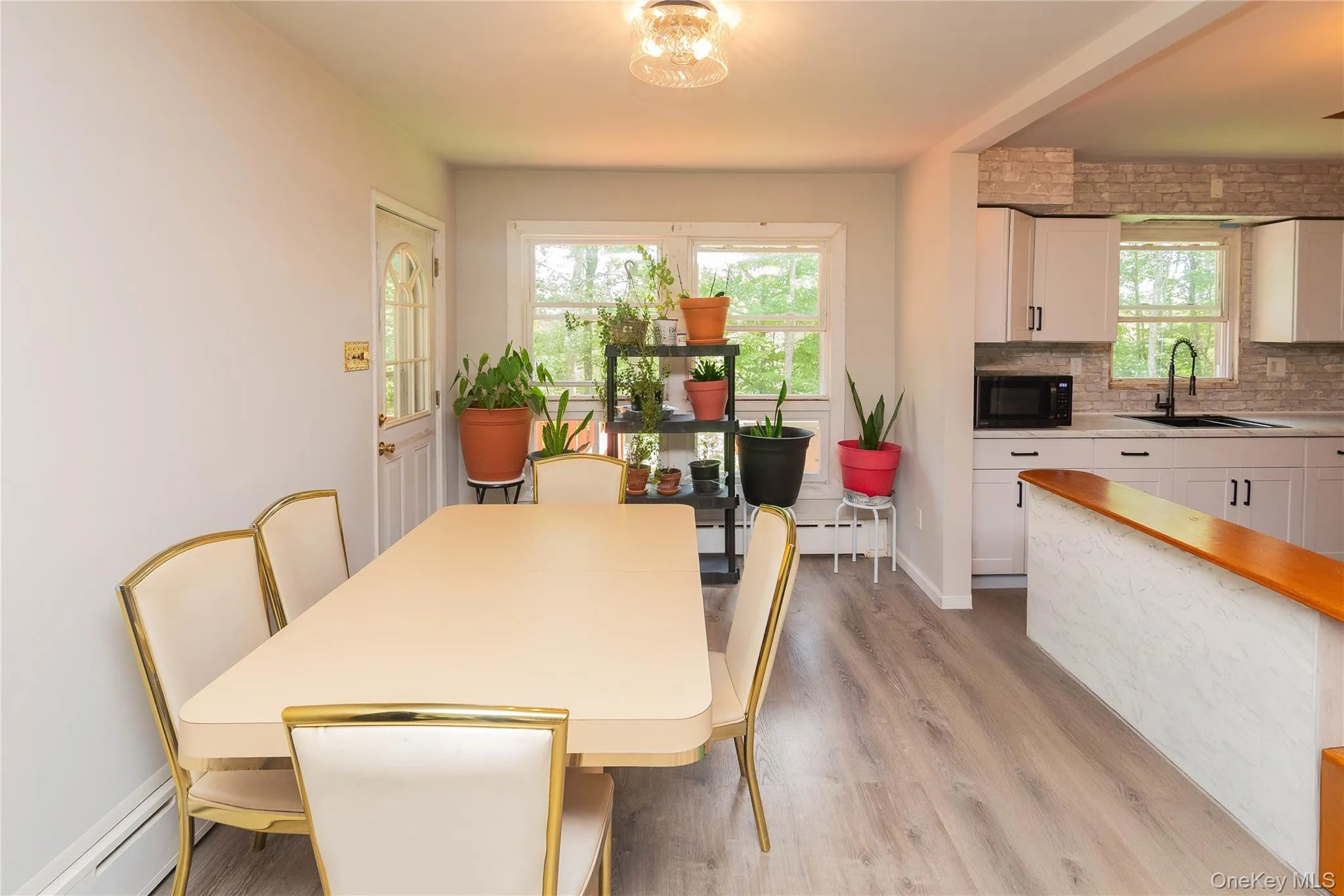 Dining room with baseboard heating, healthy amount of natural light, and light wood-style flooring Dining room with baseboard heating, healthy amount of natural light, and light wood-style flooring
