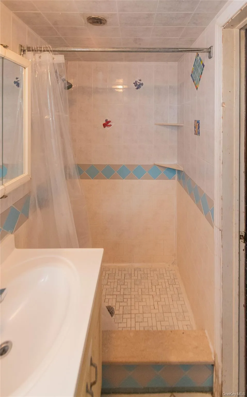 Full bathroom with tiled shower, vanity, and tile walls Full bathroom with tiled shower, vanity, and tile walls