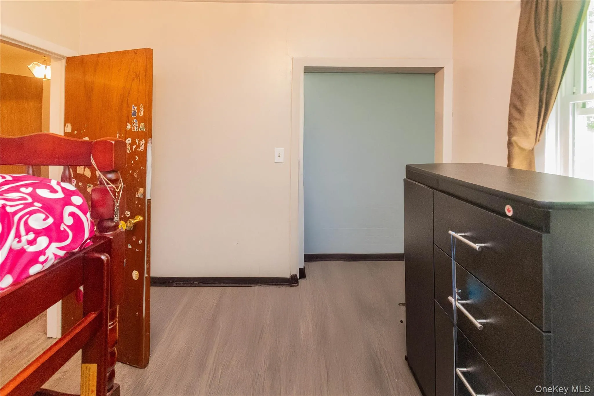 Bedroom featuring wood finished floors and baseboards Bedroom featuring wood finished floors and baseboards