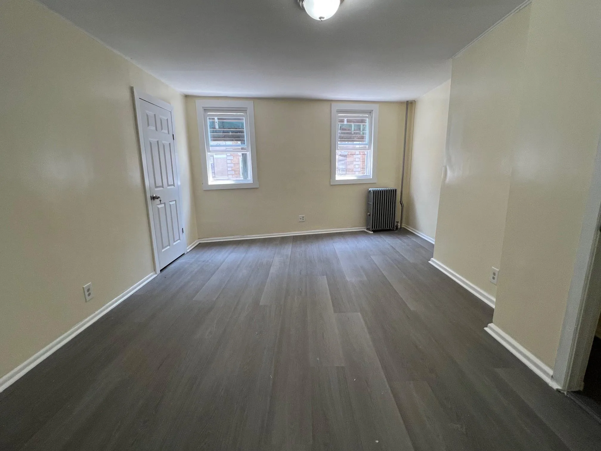 Spare room with radiator heating unit and dark wood-type flooring Spare room with radiator heating unit and dark wood-type flooring