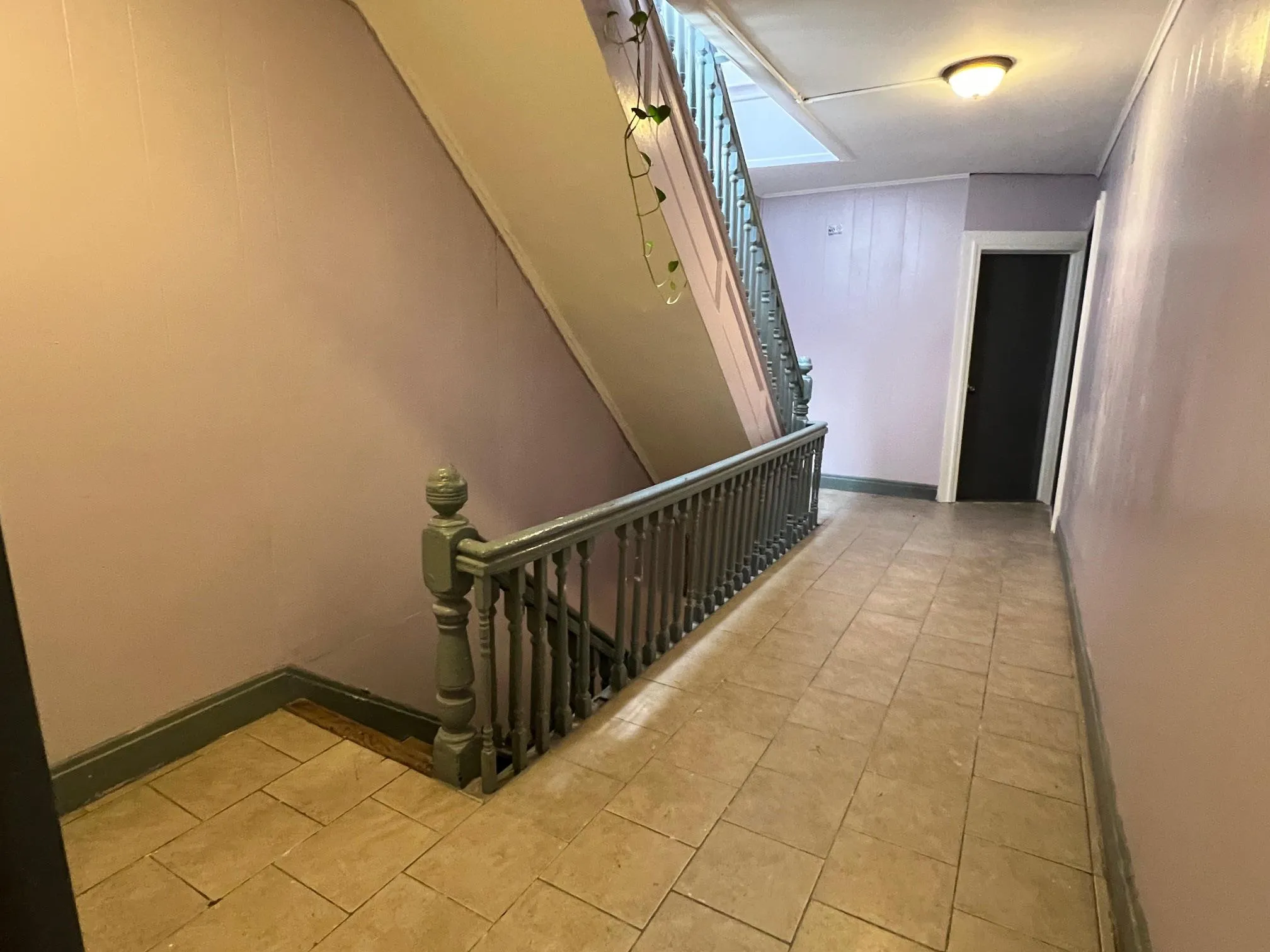 Hallway featuring stairs and light tile patterned floors Hallway featuring stairs and light tile patterned floors