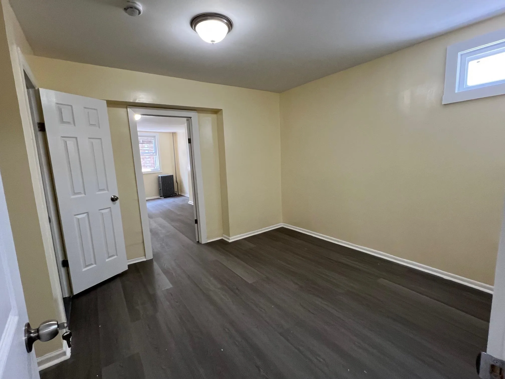 Spare room with dark wood-style floors and a smoke detector Spare room with dark wood-style floors and a smoke detector