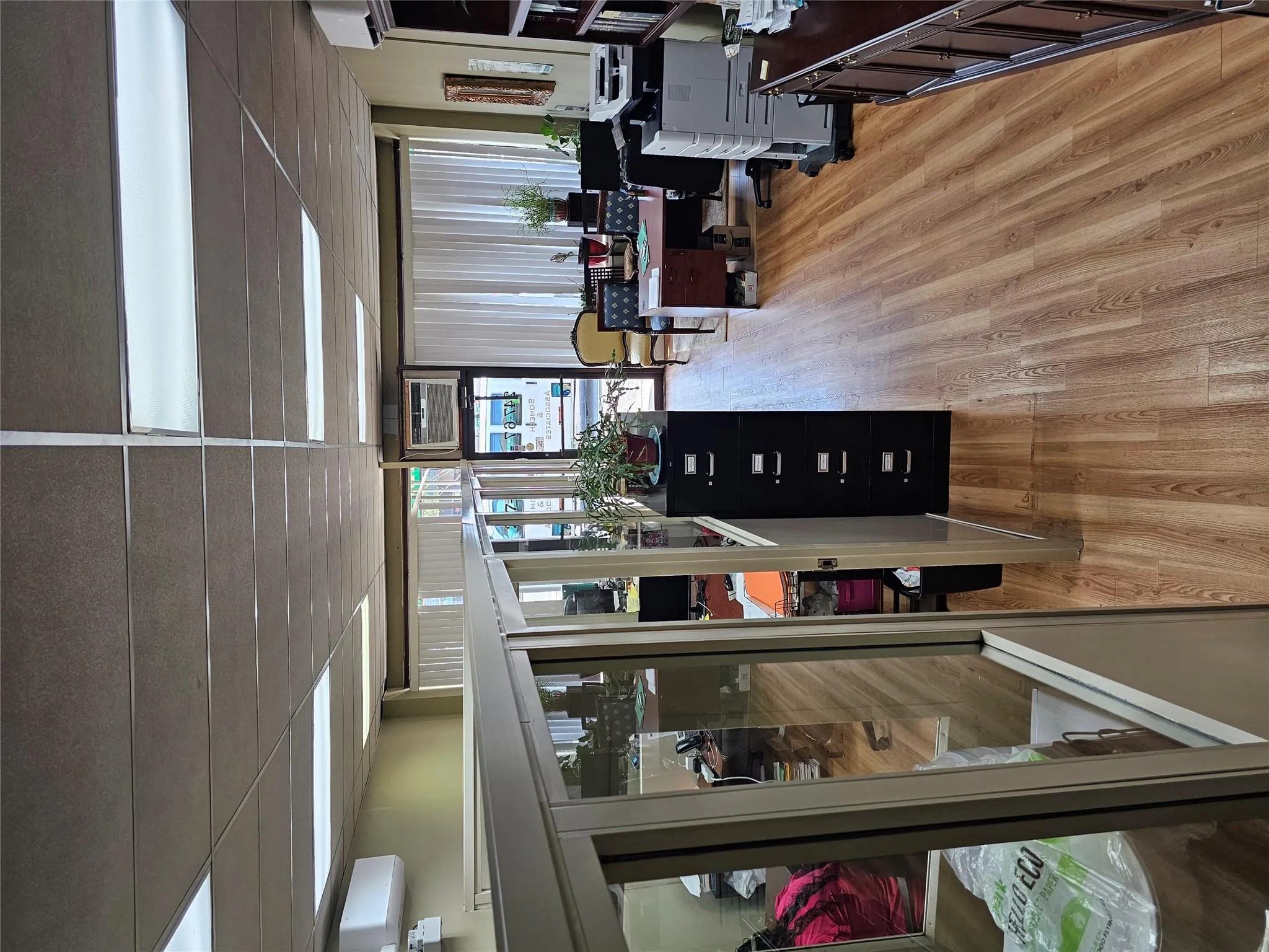 Office space with light wood-style floors, an AC wall unit, and a drop ceiling Office space with light wood-style floors, an AC wall unit, and a drop ceiling