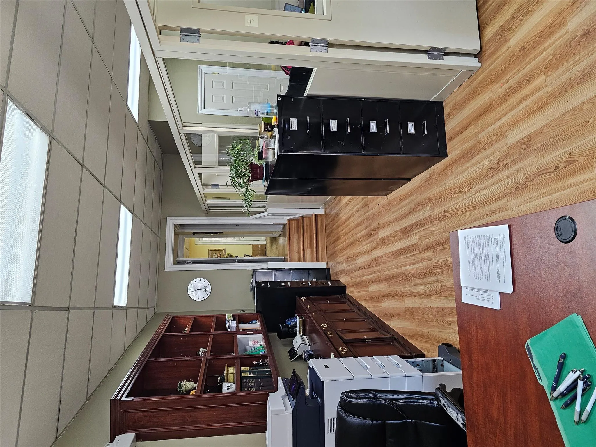Office area with light wood-style flooring and a drop ceiling Office area with light wood-style flooring and a drop ceiling