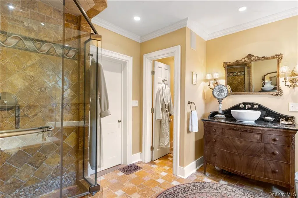 Full bath with a shower stall, vanity, crown molding, and recessed lighting Full bath with a shower stall, vanity, crown molding, and recessed lighting