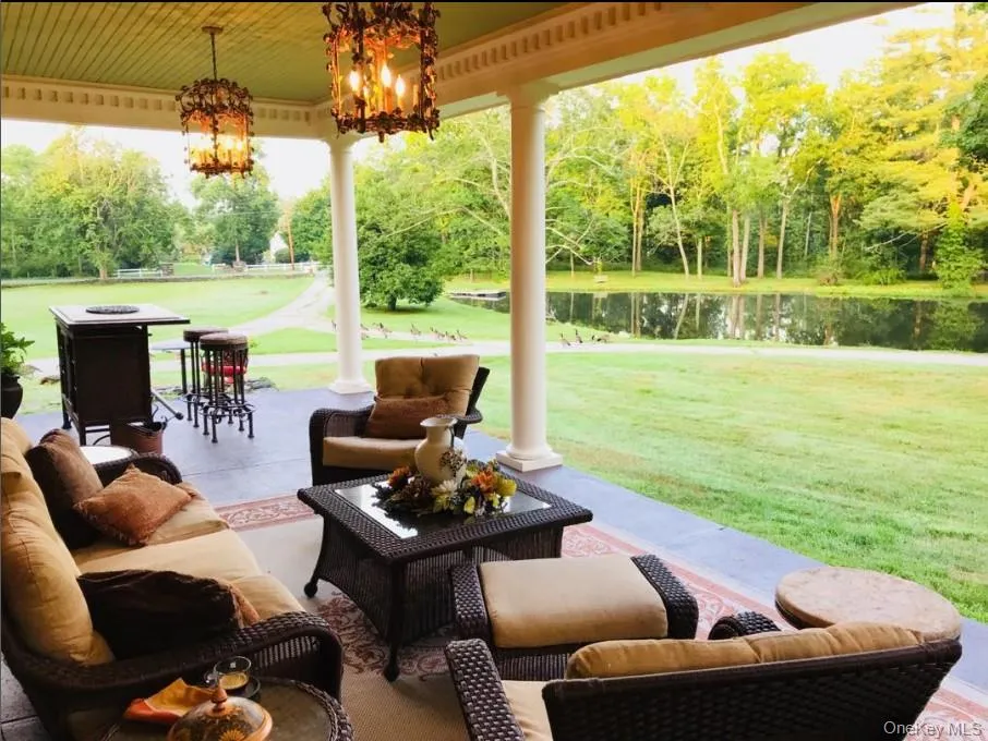 View of patio / terrace with view of wooded area, a water view, and outdoor lounge area View of patio / terrace with view of wooded area, a water view, and outdoor lounge area