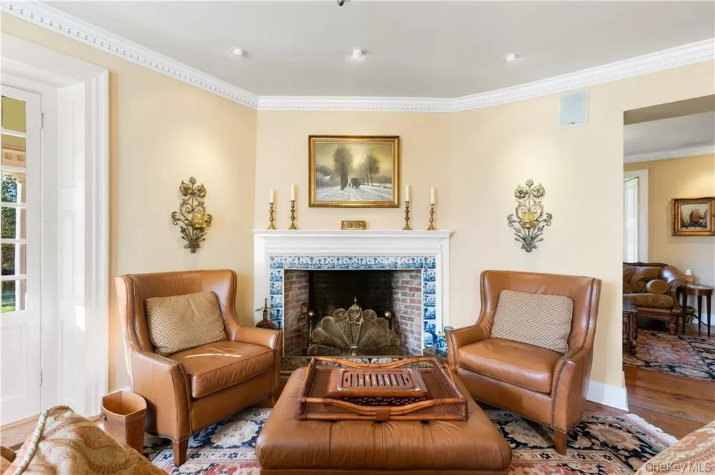 Living area featuring ornamental molding, wood finished floors, and a fireplace Living area featuring ornamental molding, wood finished floors, and a fireplace