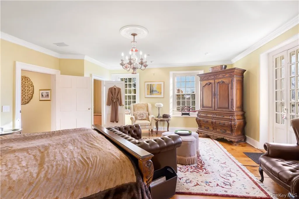 Bedroom featuring a chandelier, light wood-style floors, and crown molding Bedroom featuring a chandelier, light wood-style floors, and crown molding