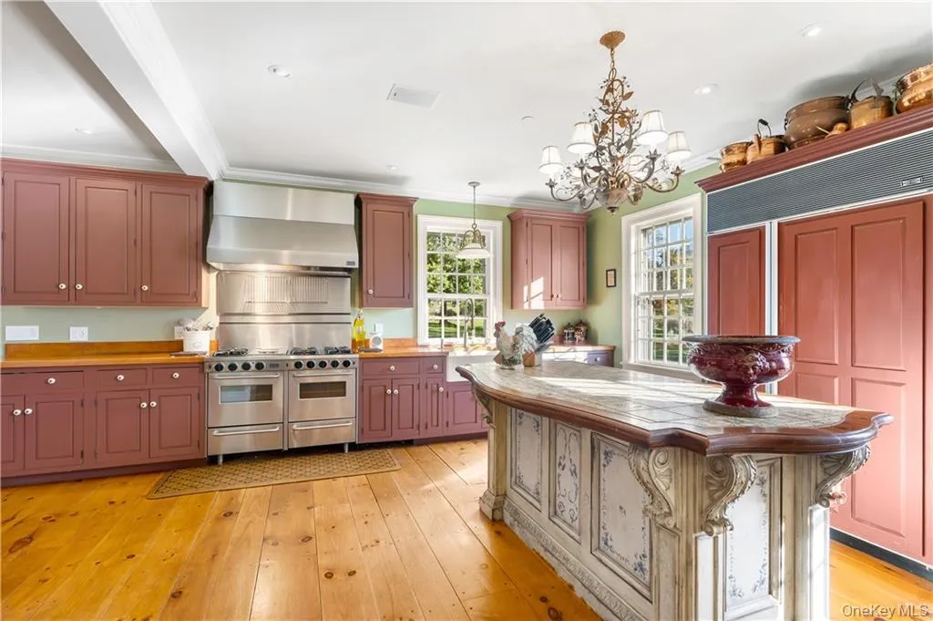 Kitchen with high quality appliances, wall chimney exhaust hood, hanging light fixtures, a chandelier, and crown molding Kitchen with high quality appliances, wall chimney exhaust hood, hanging light fixtures, a chandelier, and crown molding