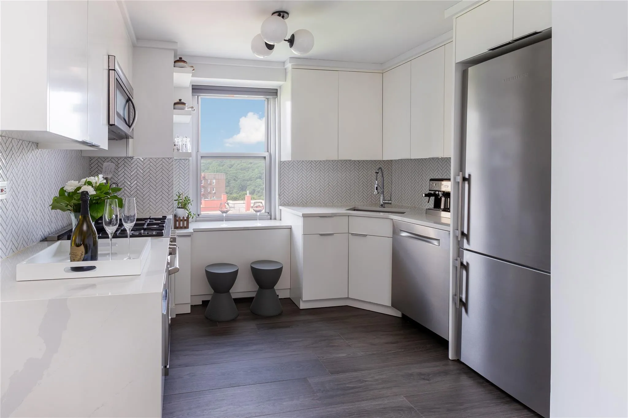 Kitchen with appliances with stainless steel finishes, white cabinets, backsplash, and modern cabinets Kitchen with appliances with stainless steel finishes, white cabinets, backsplash, and modern cabinets