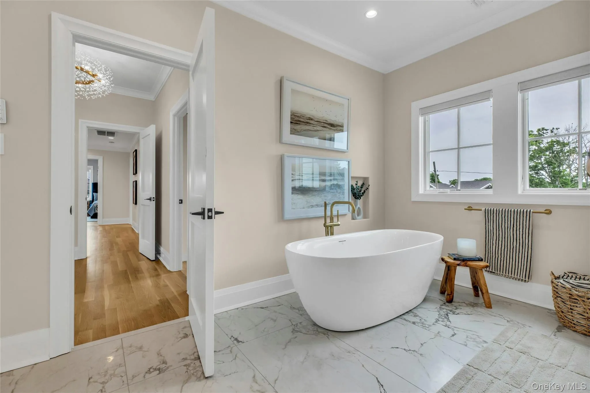 Full bath featuring marble look tiles, ornamental molding, radiator, a soaking tub, and recessed lighting Full bath featuring marble look tiles, ornamental molding, radiator, a soaking tub, and recessed lighting