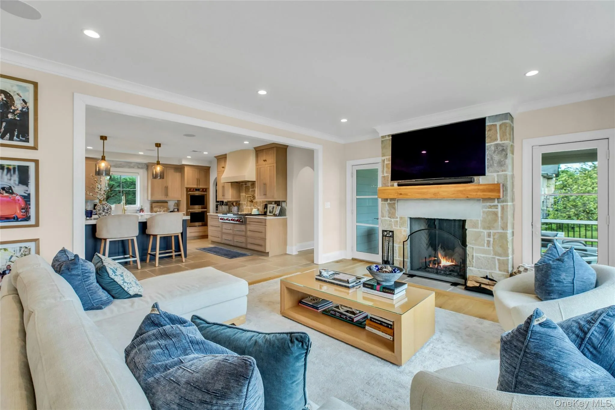 Living room with ornamental molding, a fireplace, recessed lighting, light wood-style flooring, and arched walkways Living room with ornamental molding, a fireplace, recessed lighting, light wood-style flooring, and arched walkways