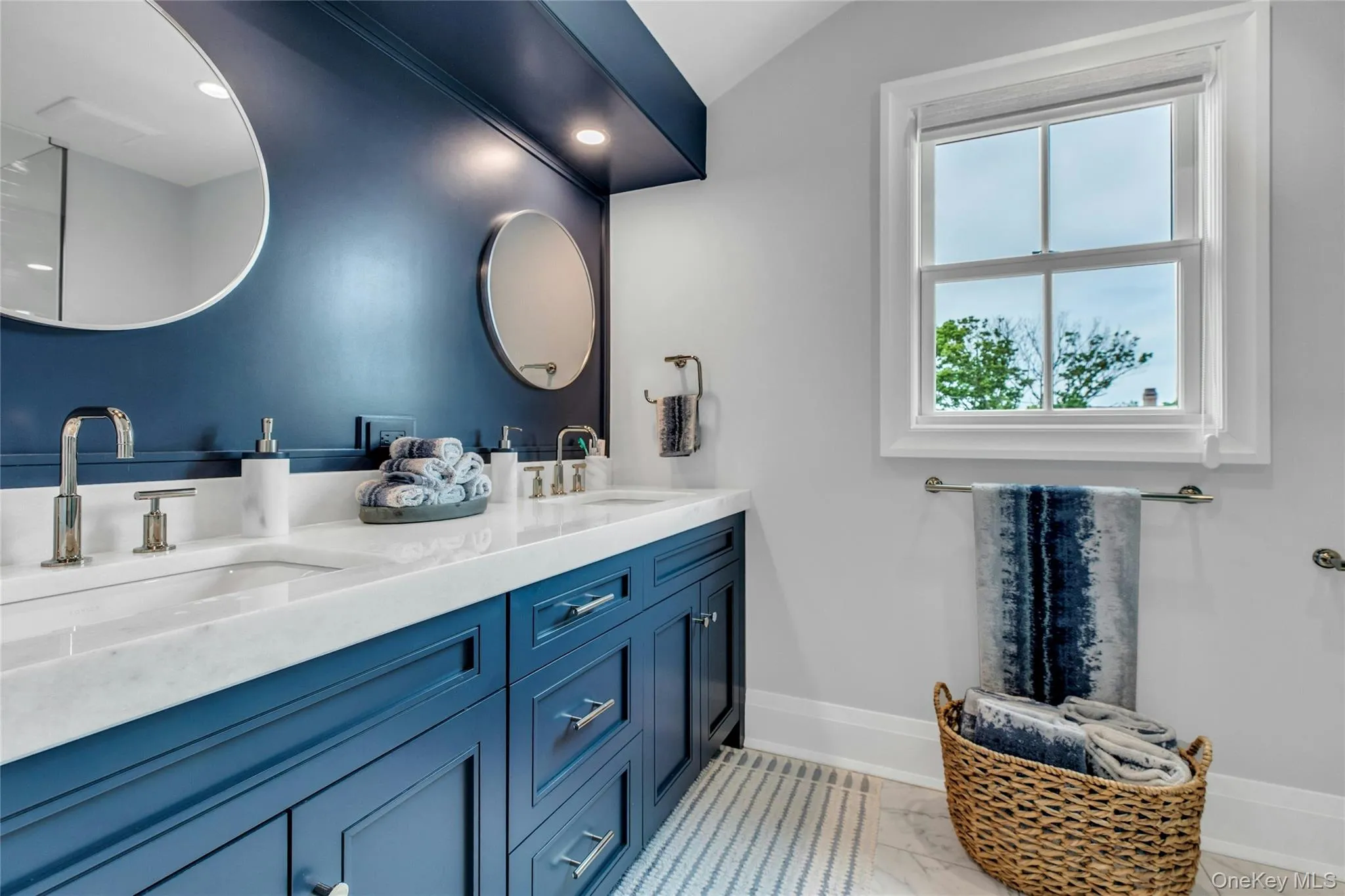 Full bathroom with double vanity and marble look tiles Full bathroom with double vanity and marble look tiles