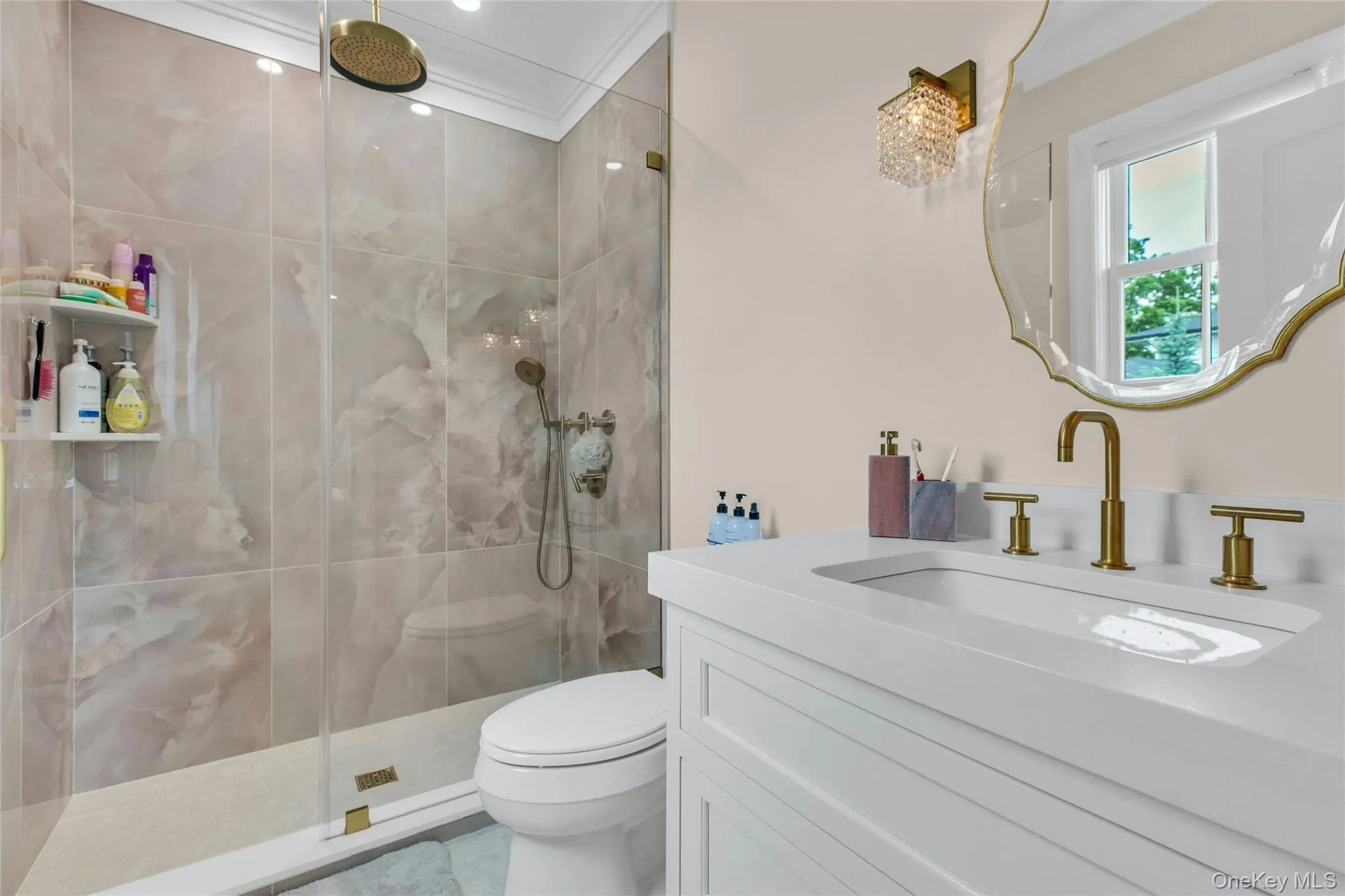 Bathroom featuring tiled shower, vanity, and crown molding Bathroom featuring tiled shower, vanity, and crown molding