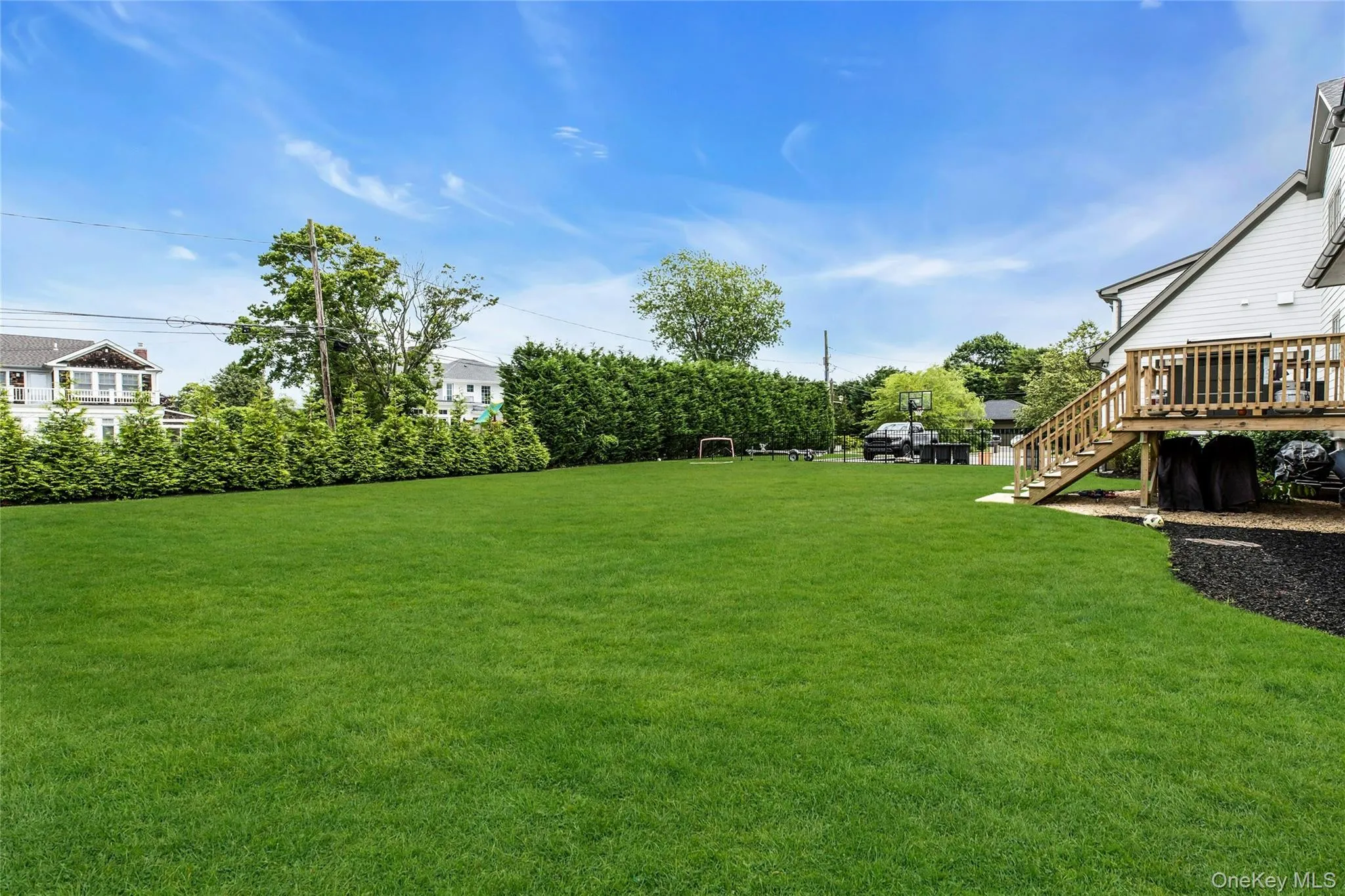 View of grassy yard featuring stairs and a deck View of grassy yard featuring stairs and a deck