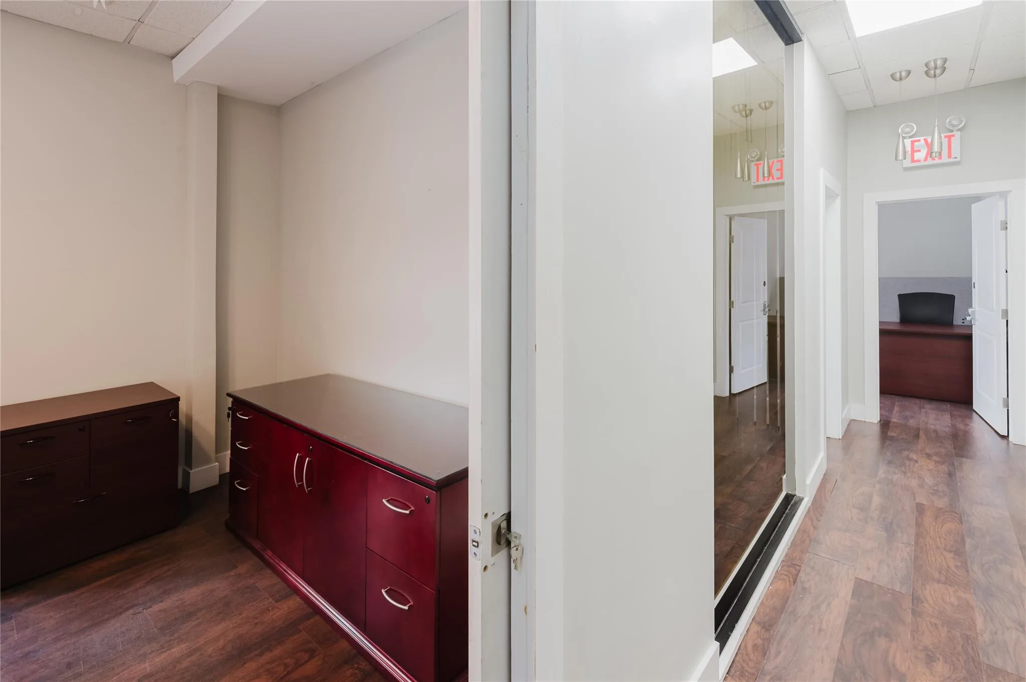 Hallway with a paneled ceiling and dark wood-style flooring Hallway with a paneled ceiling and dark wood-style flooring