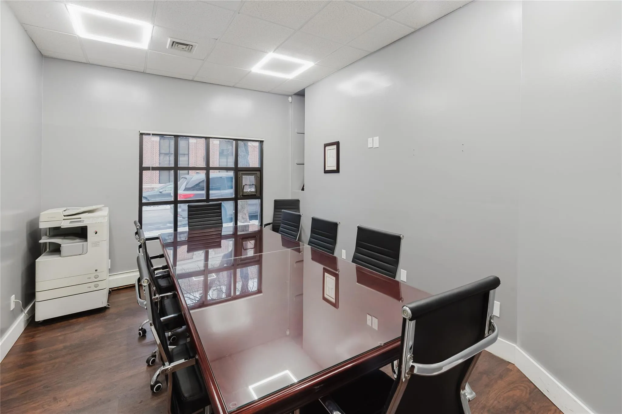 Dining room featuring a drop ceiling and wood finished floors Dining room featuring a drop ceiling and wood finished floors