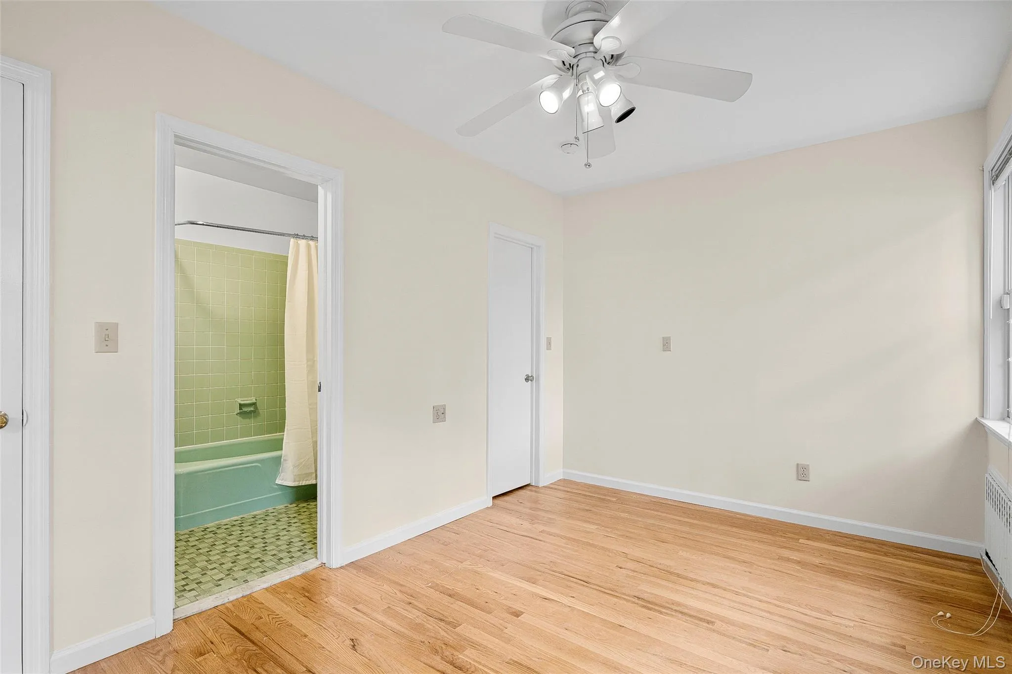 Unfurnished bedroom with light wood-style flooring, connected bathroom, and a ceiling fan Unfurnished bedroom with light wood-style flooring, connected bathroom, and a ceiling fan