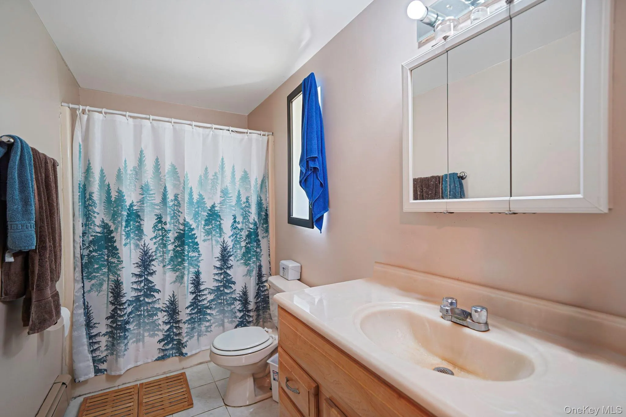 Bathroom with vanity, tile patterned flooring, a baseboard heating unit, and a shower with curtain Bathroom with vanity, tile patterned flooring, a baseboard heating unit, and a shower with curtain