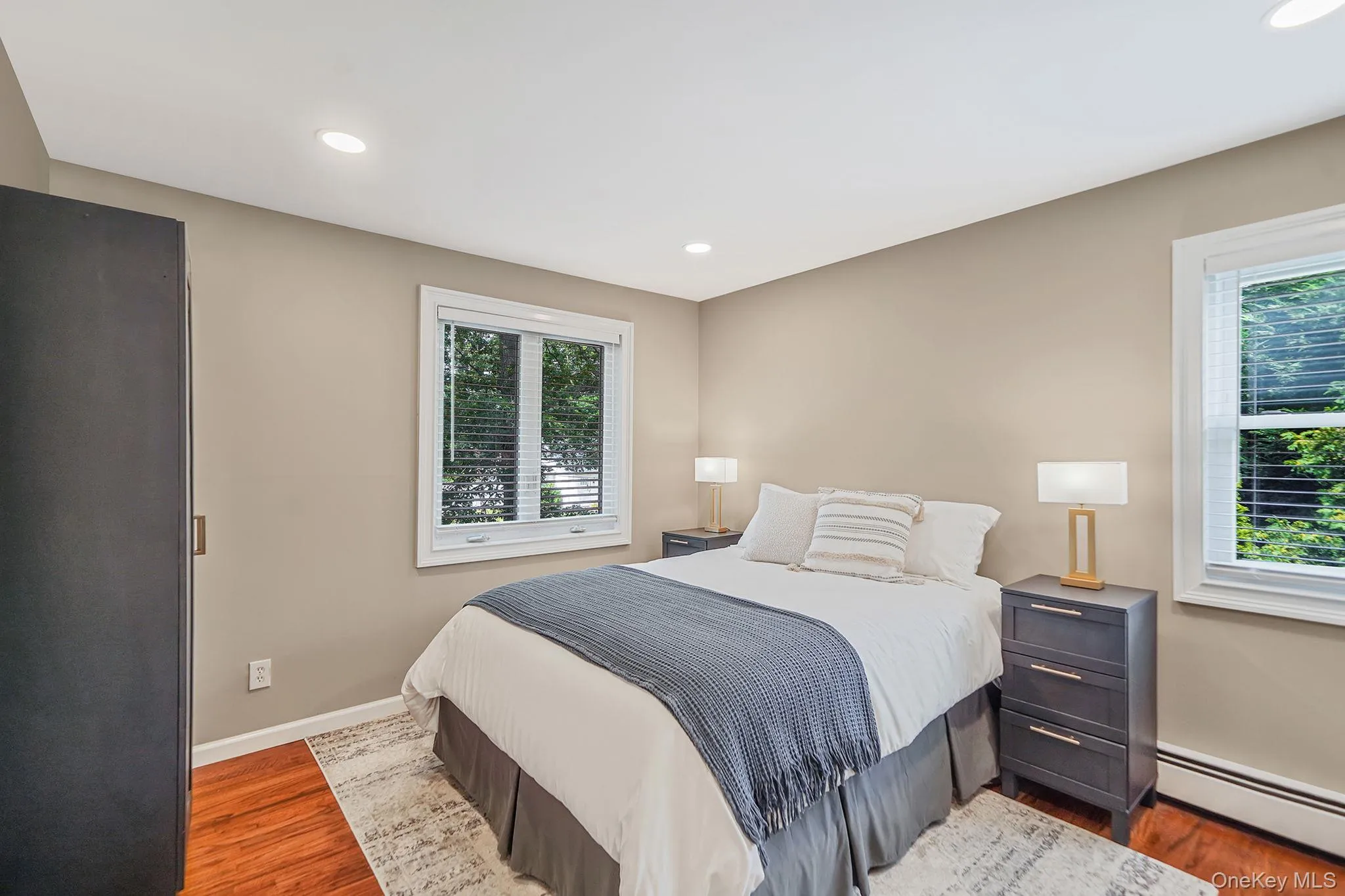Bedroom featuring baseboard heating, wood finished floors, and recessed lighting Bedroom featuring baseboard heating, wood finished floors, and recessed lighting