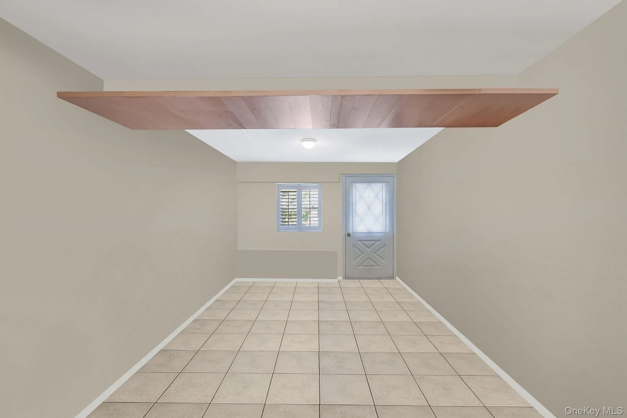 Unfurnished room featuring wood ceiling and light tile patterned floors Unfurnished room featuring wood ceiling and light tile patterned floors