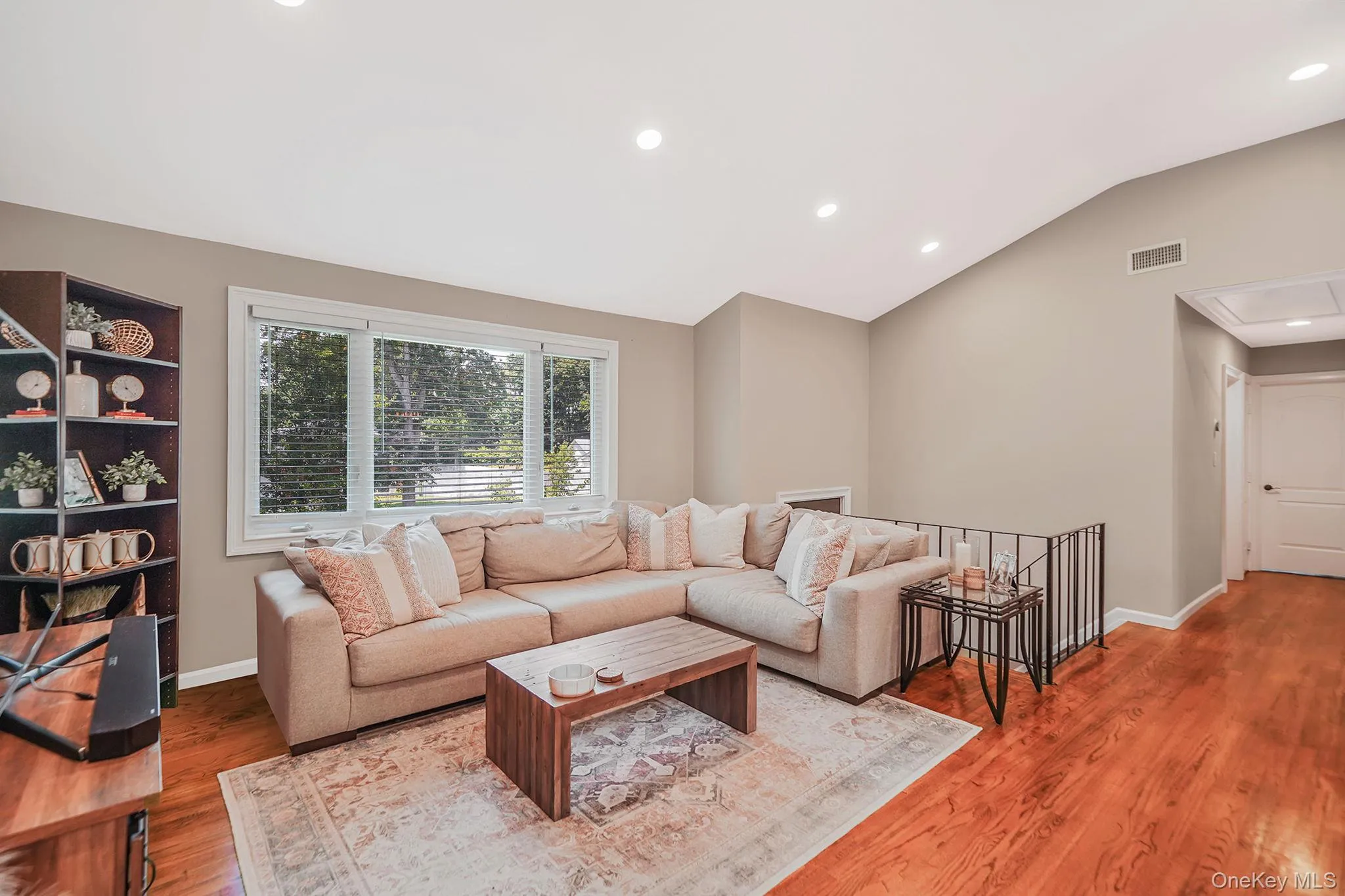 Living room with recessed lighting, lofted ceiling, and light wood-style floors Living room with recessed lighting, lofted ceiling, and light wood-style floors