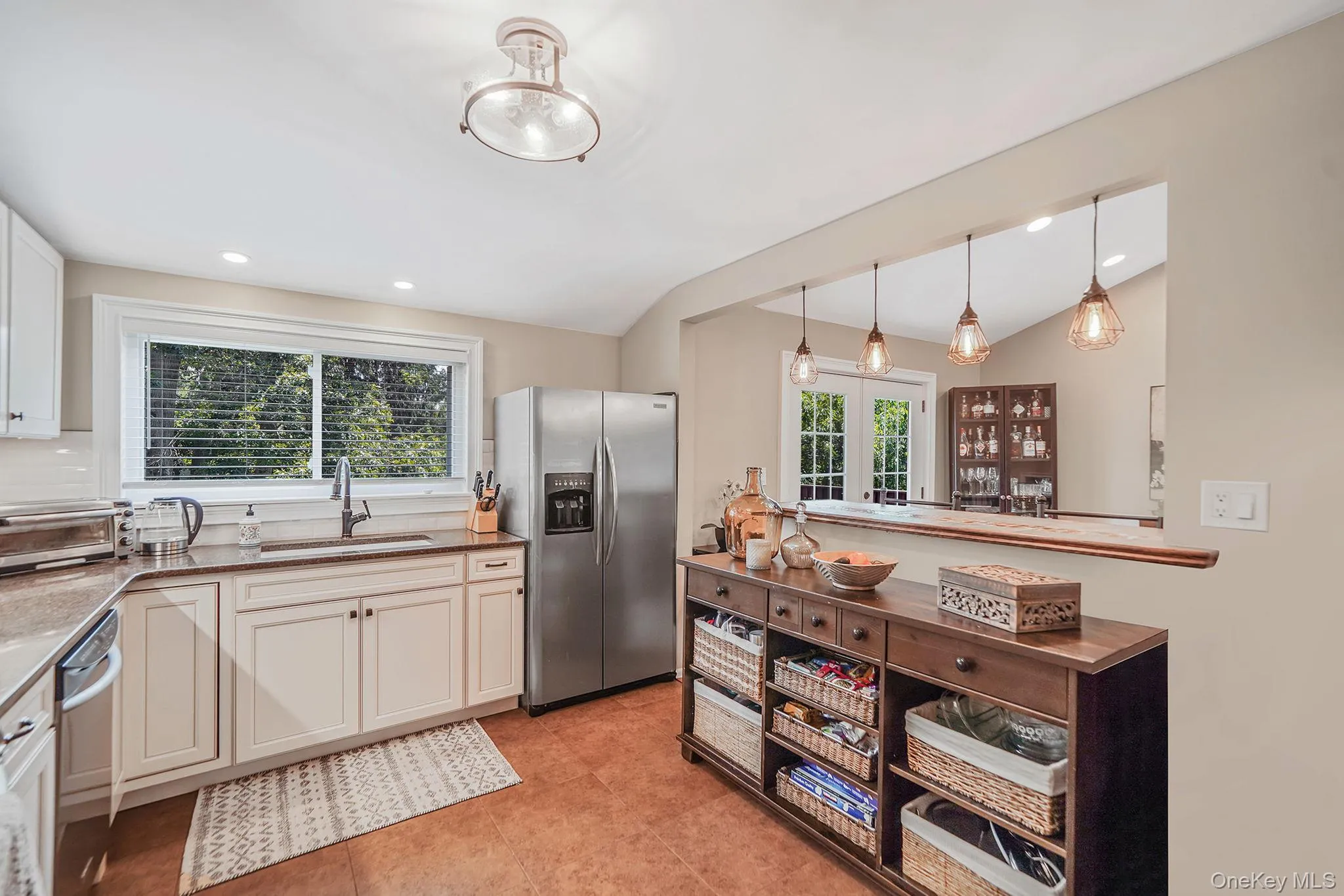 Kitchen with appliances with stainless steel finishes, plenty of natural light, pendant lighting, recessed lighting, and lofted ceiling Kitchen with appliances with stainless steel finishes, plenty of natural light, pendant lighting, recessed lighting, and lofted ceiling