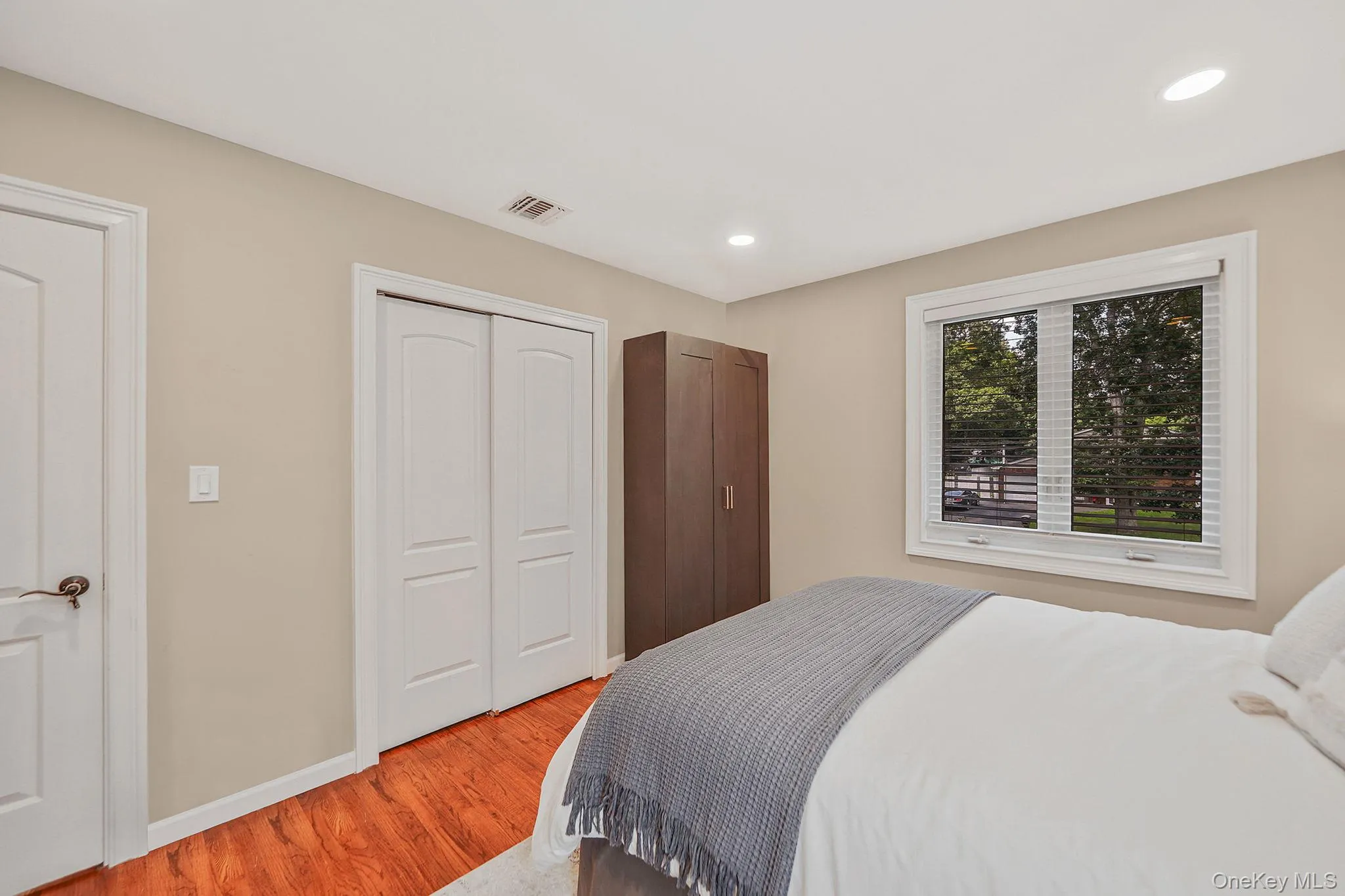 Bedroom with light wood finished floors, recessed lighting, and a closet Bedroom with light wood finished floors, recessed lighting, and a closet