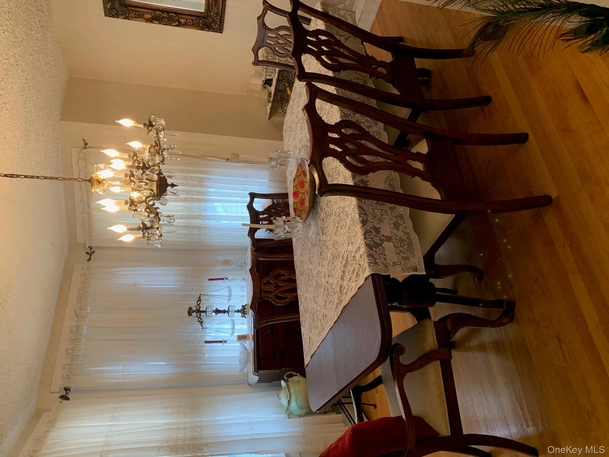 Dining room with hardwood / wood-style floors, a textured ceiling, and a chandelier Dining room with hardwood / wood-style floors, a textured ceiling, and a chandelier