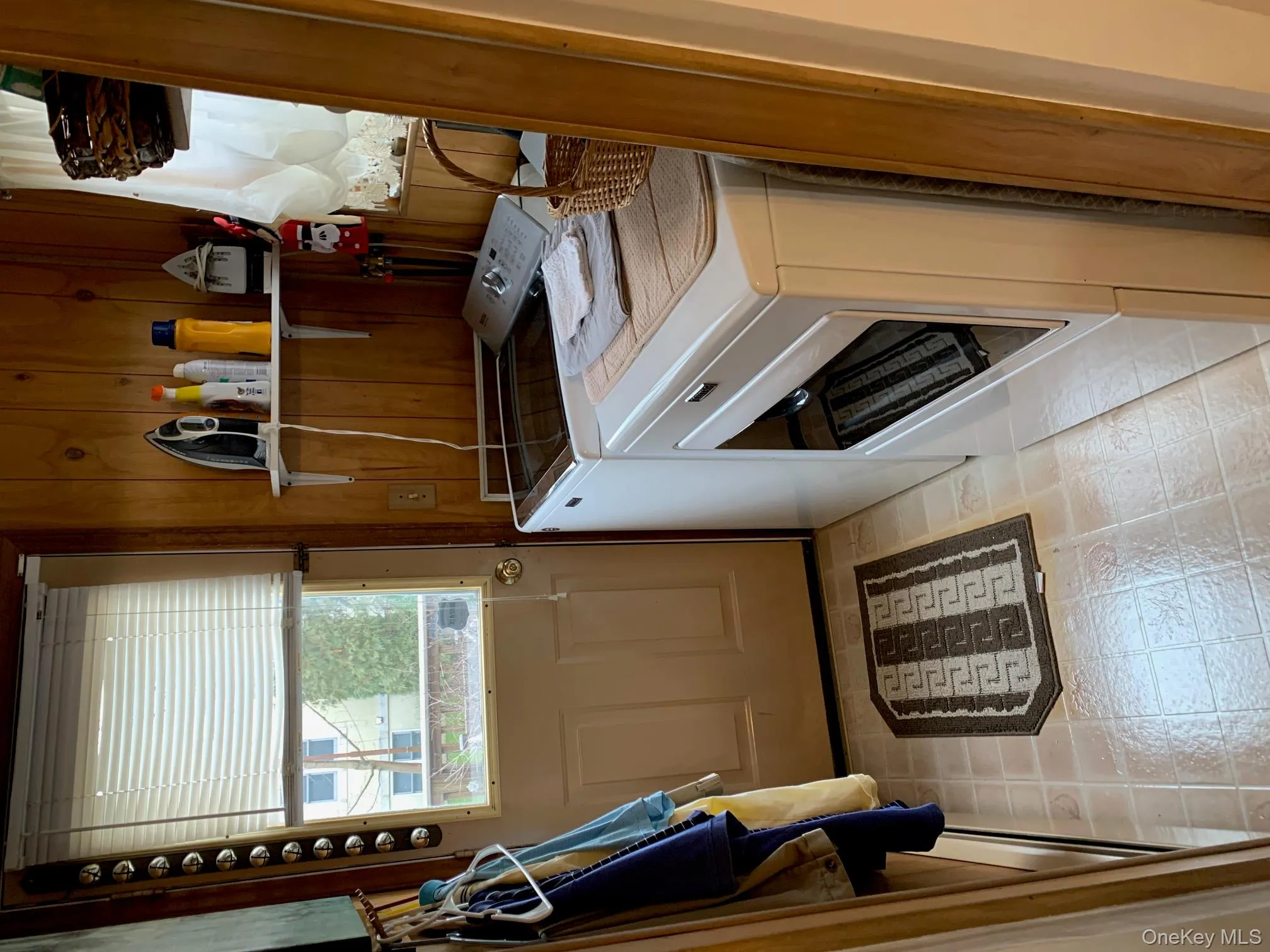 Laundry area with independent washer and dryer and wooden walls Laundry area with independent washer and dryer and wooden walls