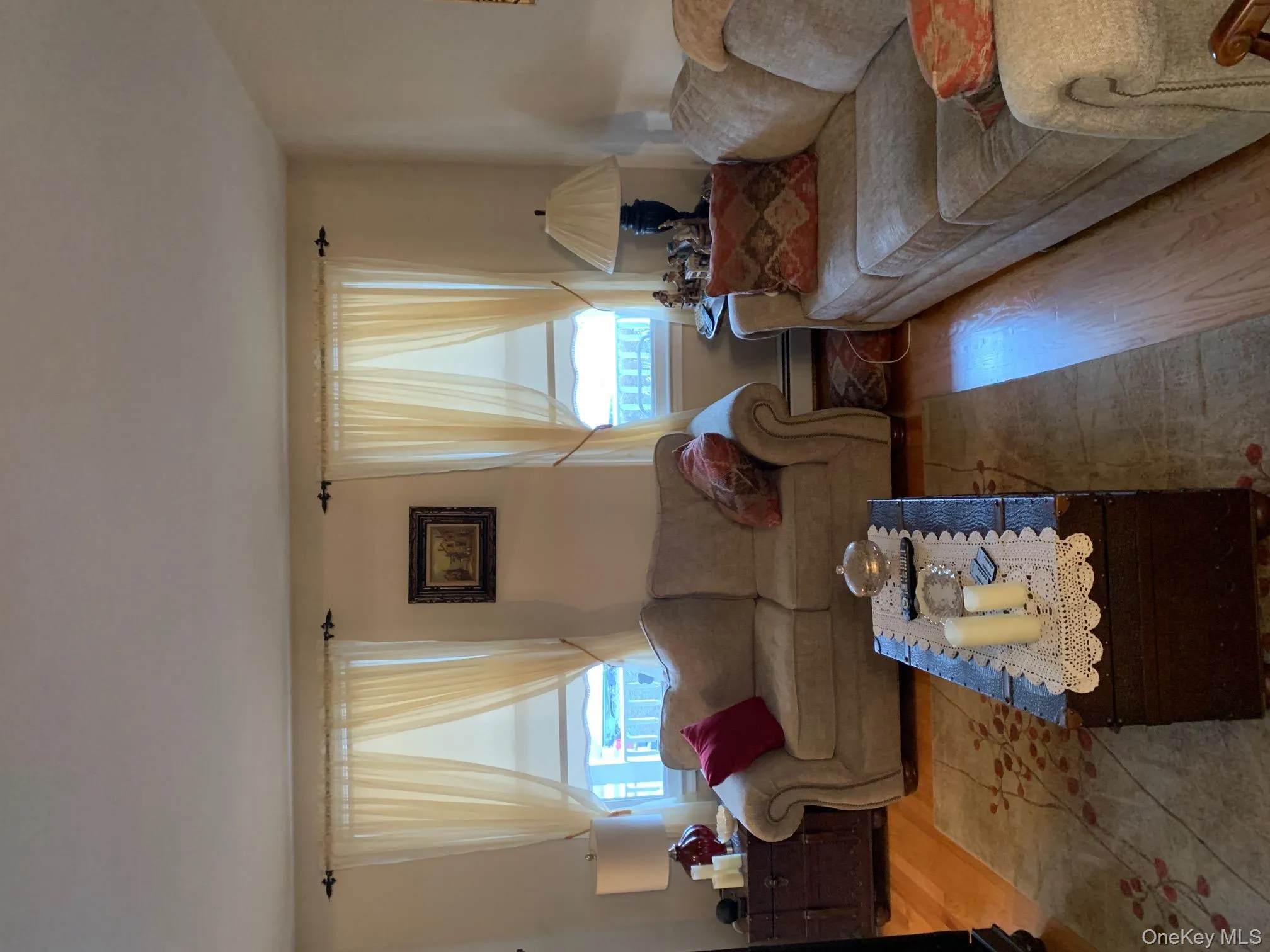 Living room with hardwood / wood-style flooring and a baseboard heating unit Living room with hardwood / wood-style flooring and a baseboard heating unit