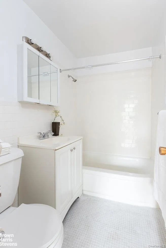 Bathroom featuring vanity, shower / bathtub combination, and light tile patterned floors Bathroom featuring vanity, shower / bathtub combination, and light tile patterned floors