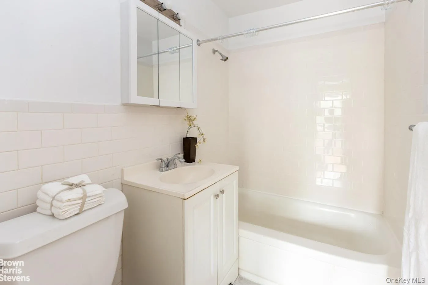 Full bath with vanity, tile walls, shower / bath combo with shower curtain, and decorative backsplash Full bath with vanity, tile walls, shower / bath combo with shower curtain, and decorative backsplash