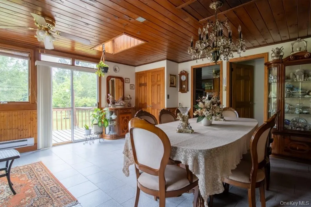 Dining area with a ceiling fan, wood ceiling, a chandelier, and baseboard heating Dining area with a ceiling fan, wood ceiling, a chandelier, and baseboard heating