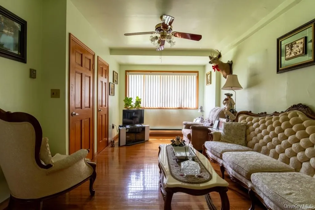 Living area featuring hardwood / wood-style floors and ceiling fan Living area featuring hardwood / wood-style floors and ceiling fan