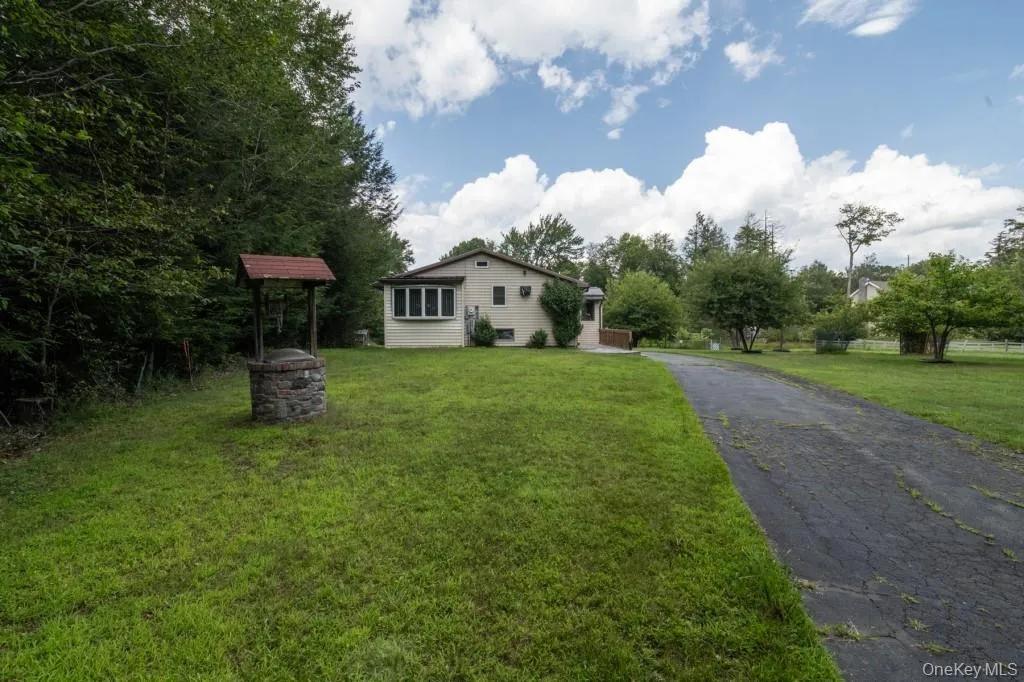 View of front of home with a front lawn and asphalt driveway View of front of home with a front lawn and asphalt driveway