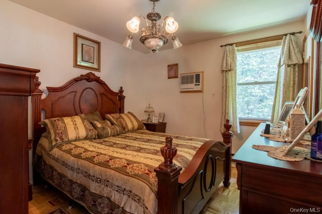 Bedroom with a chandelier and a wall mounted AC Bedroom with a chandelier and a wall mounted AC