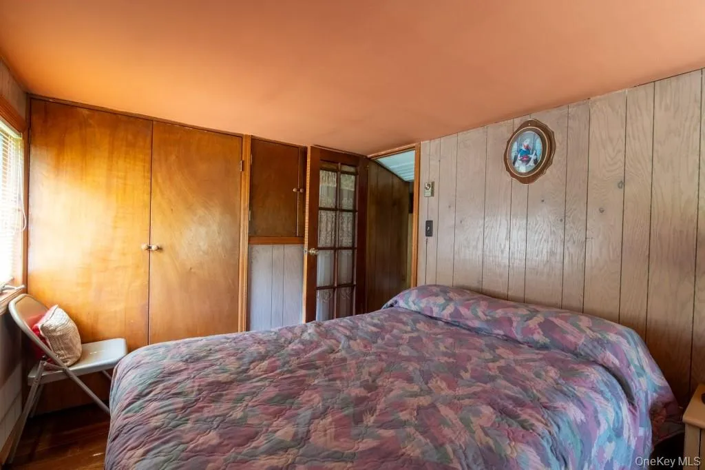 Bedroom with wooden walls and wood finished floors Bedroom with wooden walls and wood finished floors