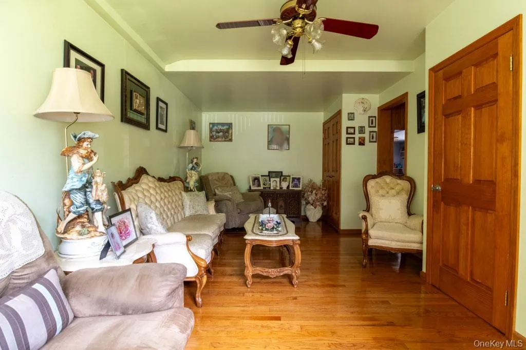 Living room featuring light wood-style floors and ceiling fan Living room featuring light wood-style floors and ceiling fan
