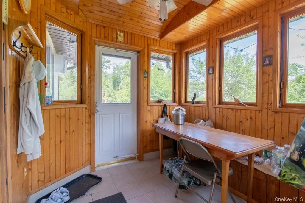 Sunroom / solarium with wood walls, wooden ceiling, and tile patterned floors Sunroom / solarium with wood walls, wooden ceiling, and tile patterned floors