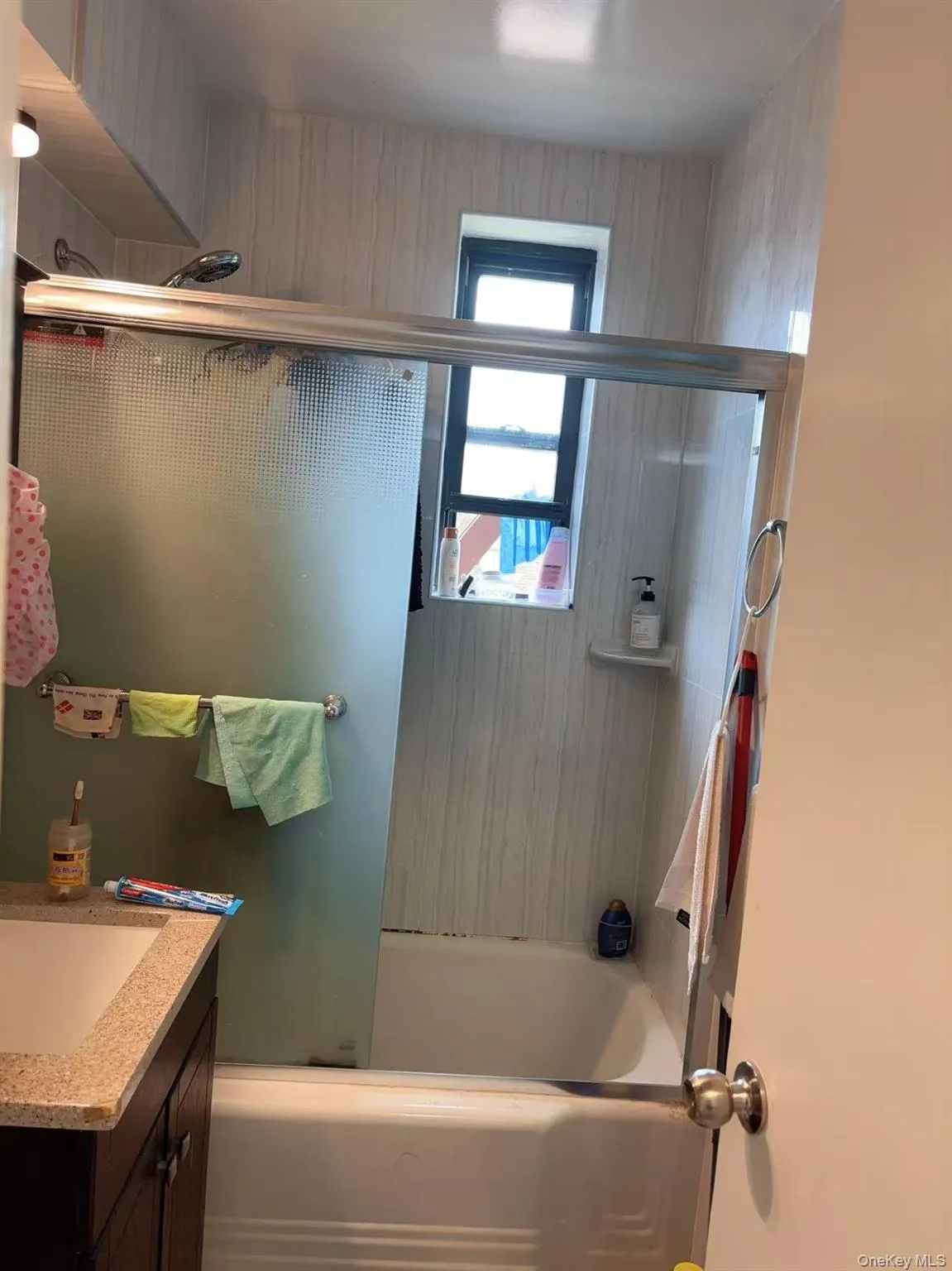 Bathroom with combined bath / shower with glass door and vanity Bathroom with combined bath / shower with glass door and vanity