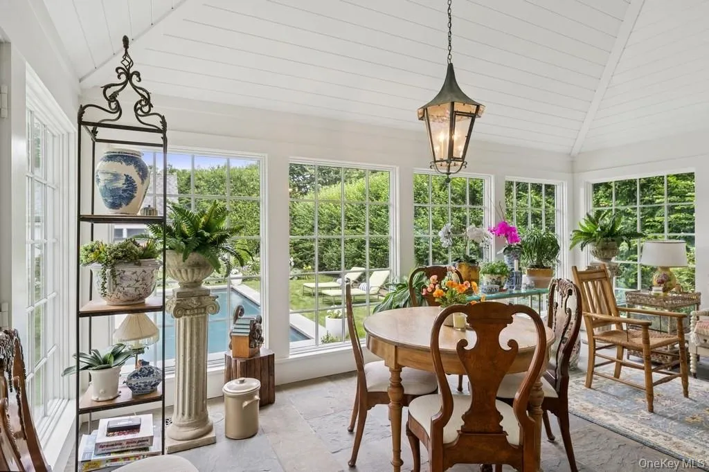 Sunroom with lofted ceiling, plenty of natural light, stone tile flooring, and wooden ceiling Sunroom with lofted ceiling, plenty of natural light, stone tile flooring, and wooden ceiling